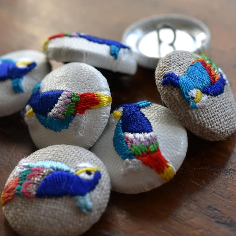 カラフル羽毛の鳥[青いオウム_parrot]刺繍のくるみボタン・ピン | mimi
